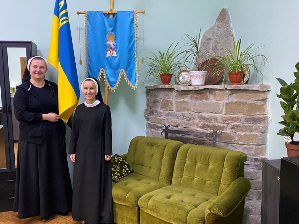 Sr. Yeronima Rybakova, left, holds part of a Ukrainian flag next to Sr. Josifa Lesnichenko, who teaches English at the school that the Sisters of the Order of St. Basil the Great operate in Ivano-Frankivsk, Ukraine. (Rhina Guidos)
