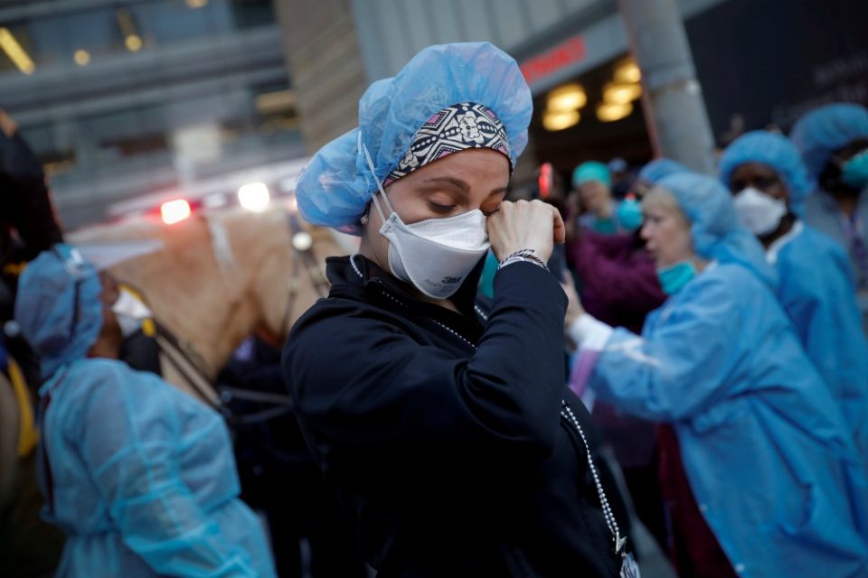 A nurse in New York City wipes away tears as police cheer and thank health care workers April 16 amid the coronavirus pandemic. (CNS/Reuters/Mike Segar) A nurse in New York City wipes away tears as police cheer and thank health care workers April 16 amid the coronavirus pandemic. (CNS/Reuters/Mike Segar)
