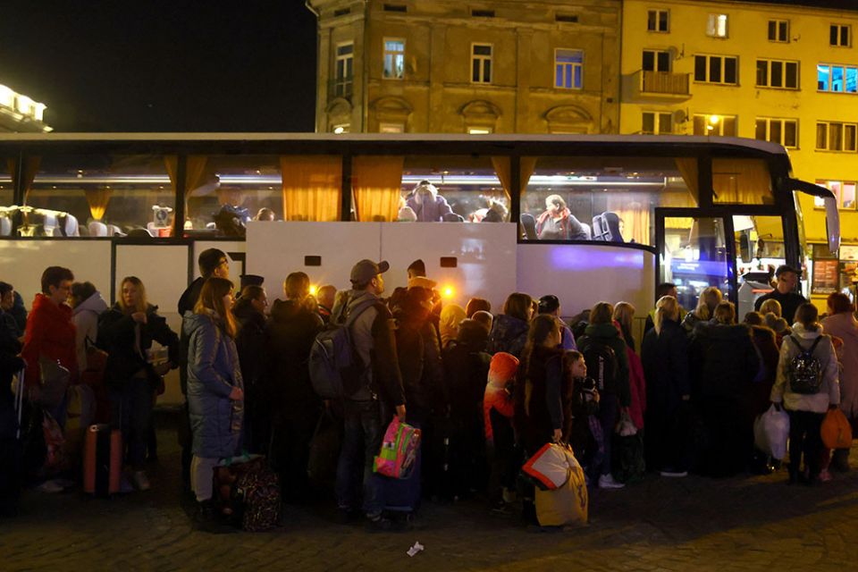Ukrainian refugees in Przemysl, Poland, wait to board a bus to take them to a temporary shelter March 23, after fleeing the Russian invasion. (CNS/Reuters/Hannah McKay)