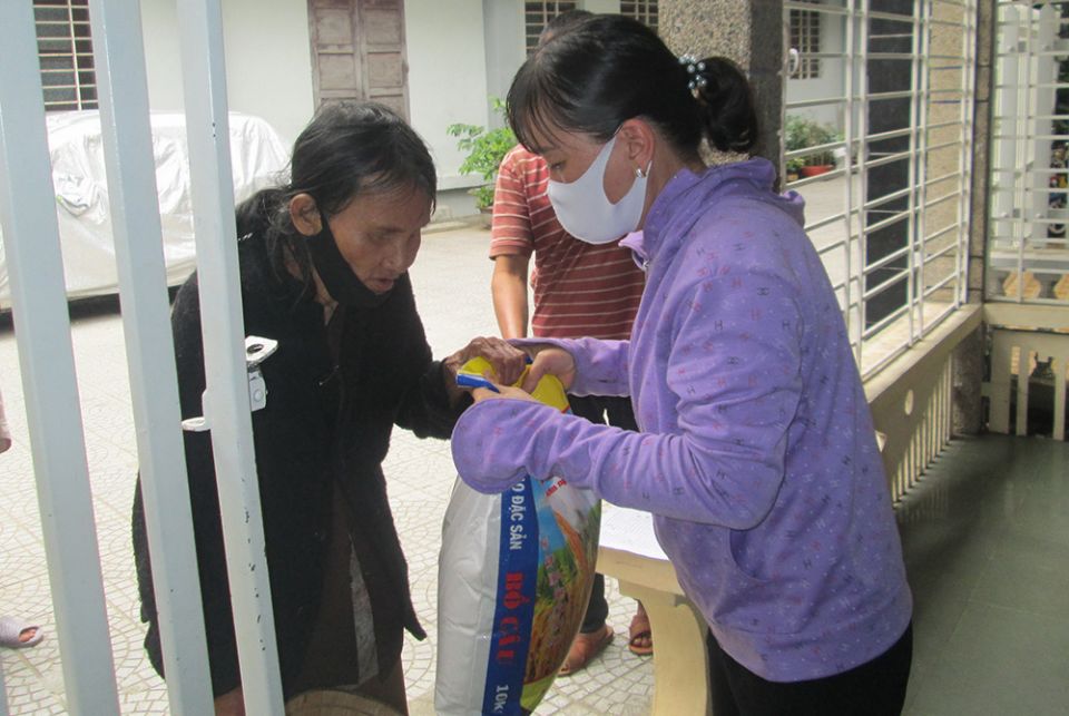 A Catholic volunteer gives aid to the mother of a pregnant woman Sept. 5 in the Huong Tra district of Thua Thie Hue province. (Peter Nguyen) 