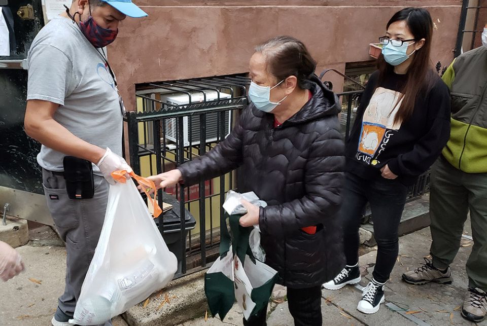 Those in line for food packages outside Cabrini Immigrant Services on Oct. 27 received a frozen chicken, milk, tea, rice, beans, potatoes and other vegetables. Many of those receiving the packages are elderly neighborhood residents of Chinatown, who thems