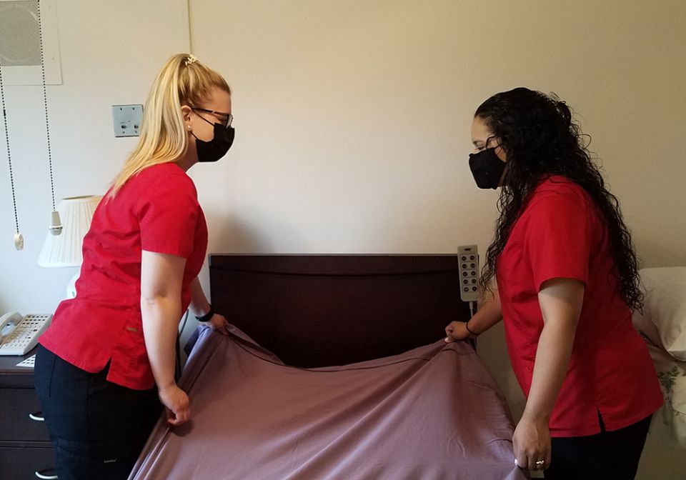Caldwell University nursing students Elizabeth Ann McChesney, left, and Stephanie Zaldivar make a bed at the St. Catherine of Siena Convent in Caldwell, New Jersey. (Courtesy of Caldwell University)