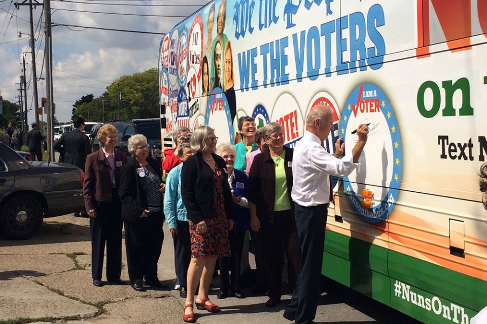 Joe Biden signs his name to the Network Nuns on the Bus official vehicle for the 2014 tour after speaking at the kickoff rally in front of the Iowa State Capitol in September 2014, when Biden was vice president. The nuns on the bus are behind him along wi Joe Biden signs his name to the Network Nuns on the Bus official vehicle for the 2014 tour after speaking at the kickoff rally in front of the Iowa State Capitol in September 2014, when Biden was vice president. The nuns on the bus are behind him along wi