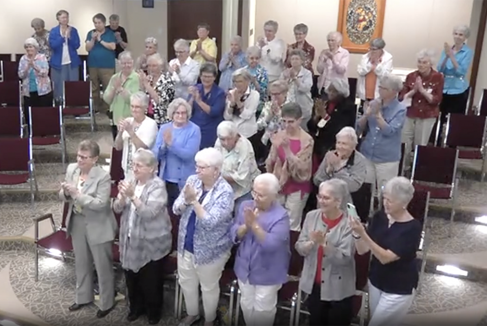 LCWR 2021 Elise Garcia ovation Sisters in the Adrian Dominican auditorium in Adrian, Michigan, give Dominican Sr. Elise García a standing ovation at the conclusion of her Aug. 11 presidential address to the Leadership Conference of Women Religious. (GSR screenshot)