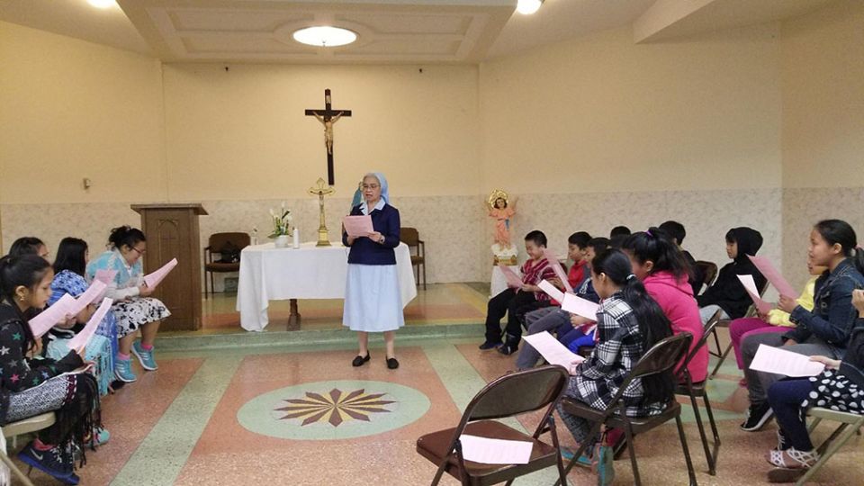 Sr. Alice Thepouthay, a member of the Sisters of Charity of St. Joan Antida and a pastoral associate for the Lao at St. Michael Parish in Milwaukee, with Hmong and Lao children (Courtesy of Alice Thepouthay)