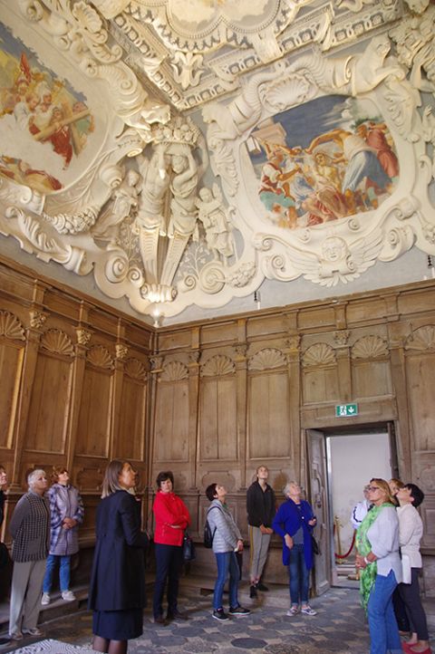A tour group looks up at the ceiling and frescoes, painted by Michelangelo Palloni, in the Pazaislis church in a room next to the central dome. (Courtesy of the Sisters of St. Casimir)