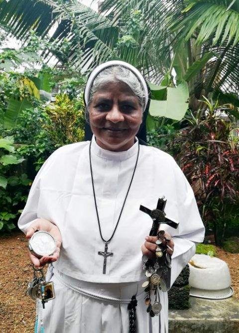 Franciscan Clarist Sr. Lissy Vadakkel, a key witness in the rape case against Bishop Franco Mulakkal, displays lockets of saints, a rosary, religious relics and a crucifix engraved with "Missionaries of Jesus," the congregation of the rape survivor.