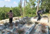 Two members from Thap Sang Hy Vong clean graves of aborted fetuses on Dec. 28, 2021, the feast of the Holy Innocents, at Ngoc Ho cemetery in Thua Thien Hue province, Vietnam. (Joachim Pham)